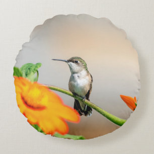 Hummingbird on a flowering plant round pillow