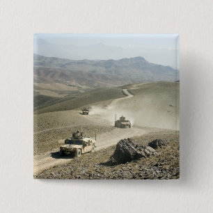 Humvees traverse rugged mountain roads 2 inch square button