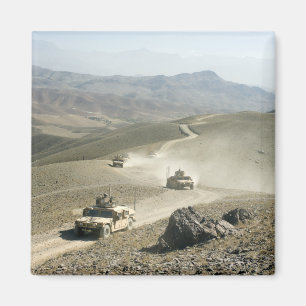 Humvees traverse rugged mountain roads magnet