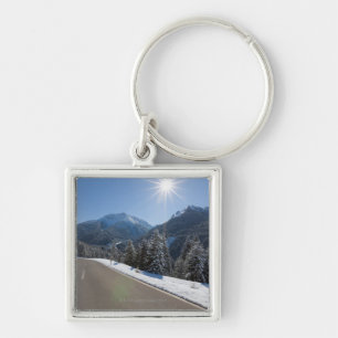 Idyllic empty road thrugh a winter landscape, 2 keychain