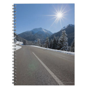 Idyllic empty road thrugh a winter landscape, notebook