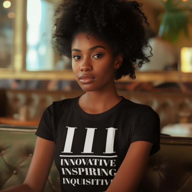 III- Innovative, Inspiring, Inquisitive T-Shirt (Young black woman wears a "III: Innovative, Inspiring, Inquisitive" black t-shirt.)