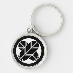 Intersecting hawk feathers in a circle keychain