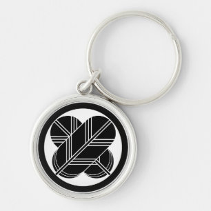 Intersecting hawk feathers with foot in circle keychain