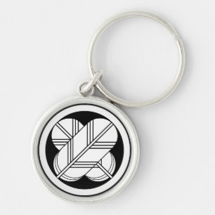 Intersecting hawk feathers with foot in circle keychain