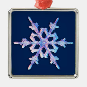 Iridescent snowflake on dark blue metal ornament