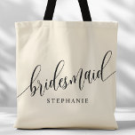 Ivory Cream Bridesmaid Modern Script Tote Bag<br><div class="desc">Show your appreciation to your bridal party with this stylish ivory cream bridesmaid tote bag. Featuring modern script and customizable with your bridesmaid's name, this tote bag is both practical and elegant. The soft colour and chic design make it perfect for carrying wedding day essentials or everyday items. This personalized...</div>