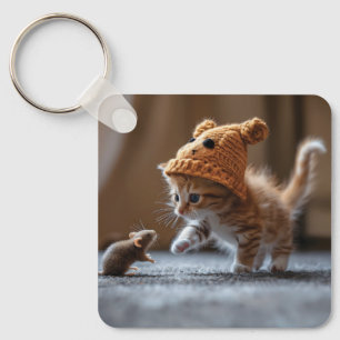 Kitten playing with a small mouse keychain