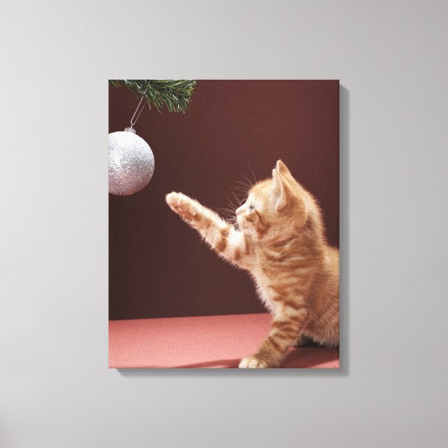 Kitten playing with Christmas bauble on tree Canvas Print (Front)