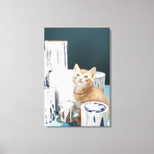 Kitten sitting amongst paint tins canvas print