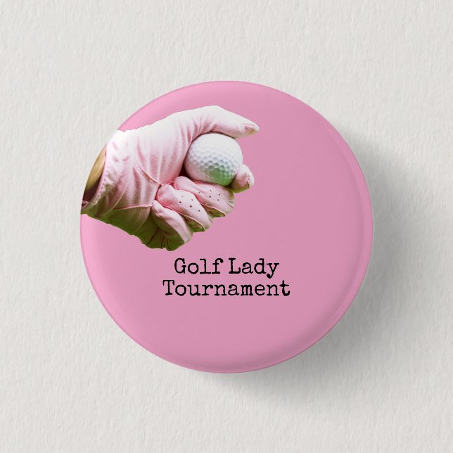 Lady golfer is holding golf ball on pinkbackground 1 inch round button (Front)