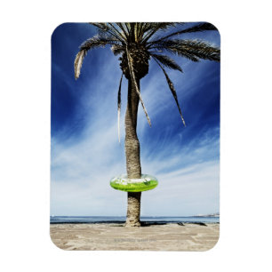 Large palm tree on a sandy beach with inflatable magnet