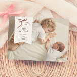 Lazo Navideño | Feliz Navidad Tarjeta con Foto Holiday Card<br><div class="desc">Celebre esta temporada con nuestra tarjeta de navidad personalizada. Este diseño minimalista y moderno muestra su foto favorita como fondo, con un delicado recuadro blanco en forma de etiqueta en la esquina superior izquierda. Un lazo rojo dibujado a mano envuelve elegantemente el año en su interior, “Feliz Navidad”, se encuentra...</div>