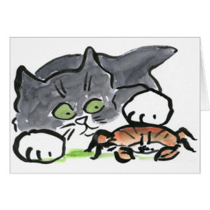 Le chaton a trouvé un crabe sur la plage