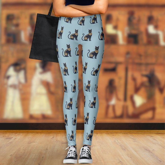 Leggings Chat noir égyptien motif Dusty bleu (A pair of light blue leggings with a pattern of Egyptian-style black and faux gold cats)