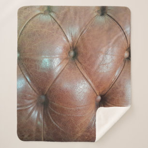 Light on brown leather sofa surface, textureabstra sherpa blanket