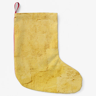 light yellow abstract textured plaster on the wall small christmas stocking