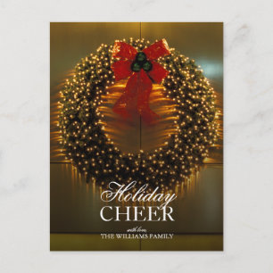 Lighted wreath with red bow against gold backdrop holiday postcard