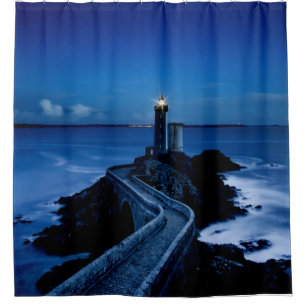 Lighthouse on wall in ocean at night