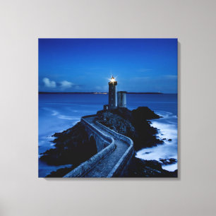 Lighthouse on wall in ocean at night canvas print