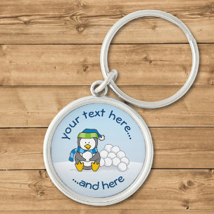 Little penguin sitting with snowballs keychain