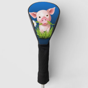 Little pink pig in green grass over blue golf head cover