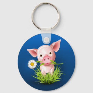 Little pink pig in green grass over blue keychain