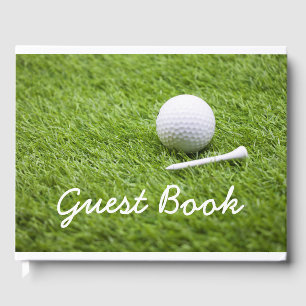 Livre D'or Boule de golf et tee blanc sont sur l'herbe verte