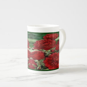 L'oeillet rouge fleurit la tasse de porcelaine