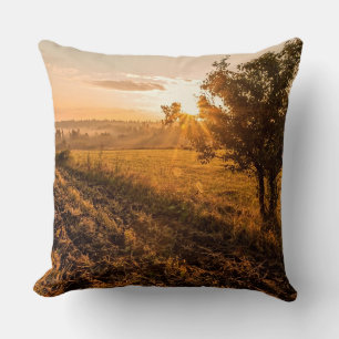 Lonely tree on the foggy field in golden sunrise throw pillow