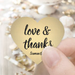 Love and Thanks Black and Gold Faux Foil Thank You Heart Sticker<br><div class="desc">Add an elegant personalized finishing touch to thank you notes, party favours, and decorations with these chic calligraphy heart shaped stickers / envelope seals. Design features gold faux metallic foil, stylish script love and thanks, and a name. All text on these versatile labels is simple to customize, and can be...</div>