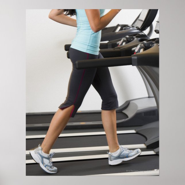 Low section of woman walking on treadmill poster (Front)