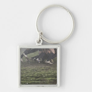 Lower section of rugby player in scrum, pushing keychain