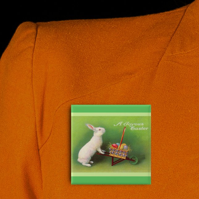 Macaron Carré 5 Cm Joyeux Oeufs du panier de lapin de Pâques (Joyous Easter white rabbit pushing wheelbarrow coloured eggs on green pin back button.)
