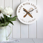 Made With Love In Nana's Kitchen Whisk Bakery Large Clock<br><div class="desc">Simple, clean, and minimal style bakery clock design featuring "made with love in Nana's Kitchen. Faux natural woodgrain bakers rolling pin and whisk design are crossing each other and placed in the centre of the clock. Customize with monogram initials. Perfect gift for your nana or grandma. All artwork by Moodthology....</div>