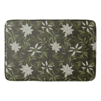 Magnolia and green leaves on black bath mat