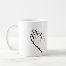 main noire et blanche sur une tasse à café