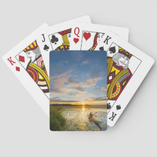 Male kayaker paddling sea kayak on still water playing cards