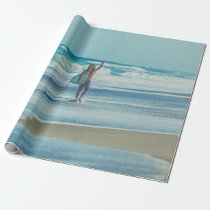 Man carrying surfboard at beach wrapping paper