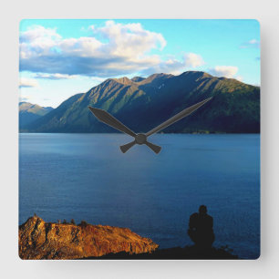 Man Crouches Contemplating Sunset Light in Alaska Square Wall Clock