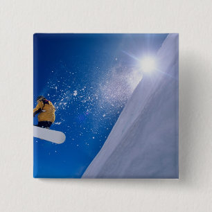 Man flying through the air on a snowboard with 2 inch square button