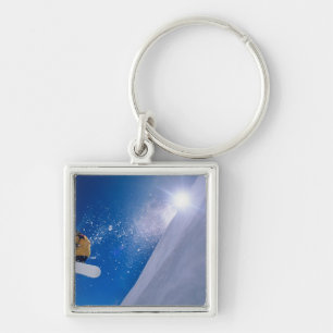 Man flying through the air on a snowboard with keychain