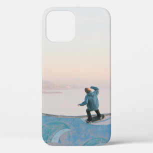 Man in blue skateboarding on wall in beach iPhone 12 case