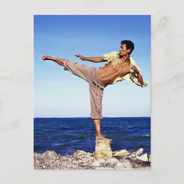 Man in martial arts kicking position, on beach, postcard (Front)