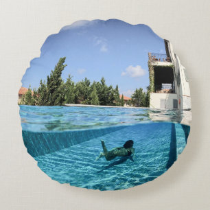 Man in swimming pool in the morning round pillow