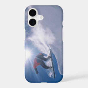 Man jumping off a large cornince on a snowboard