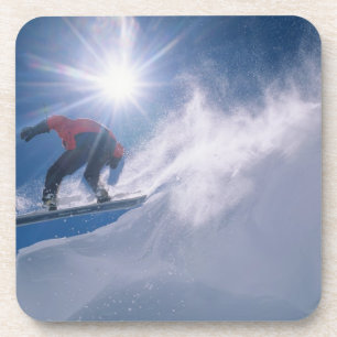 Man jumping off a large cornince on a snowboard coaster
