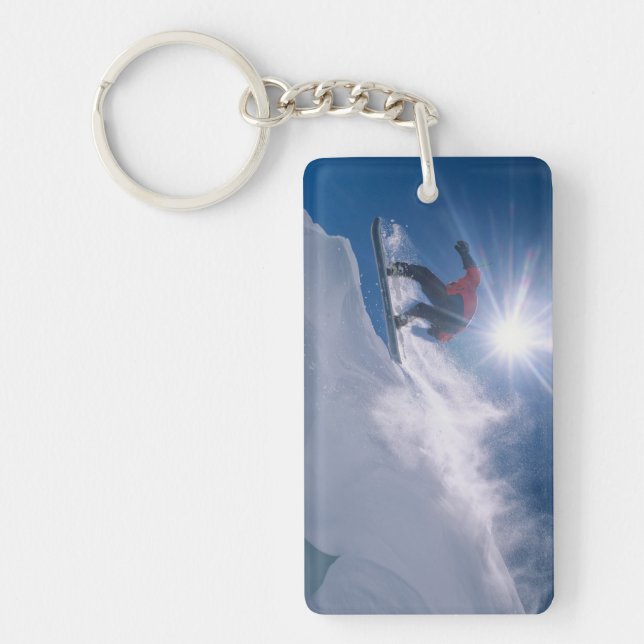 Man jumping off a large cornince on a snowboard keychain (Front)