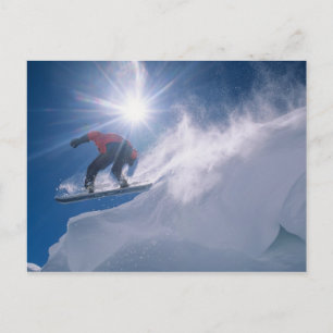 Man jumping off a large cornince on a snowboard postcard