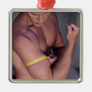 Man measuring bicep metal ornament